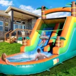 Tobogán inflable tropical con palmeras y resbaladilla